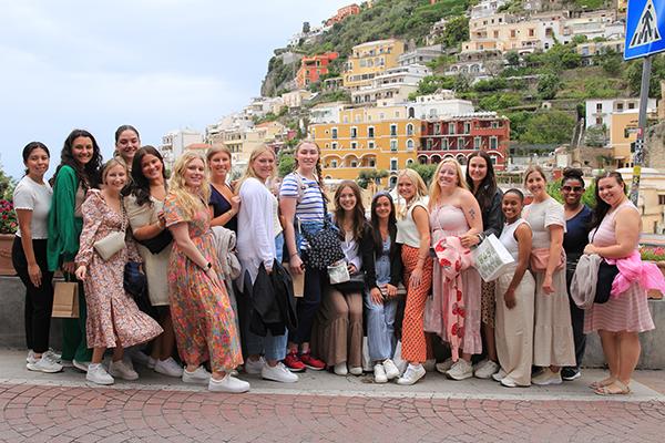 A group of SLP students posed together in front of the Italian coast.