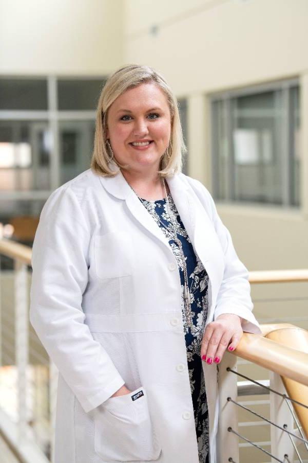 A nurse practitioner smiling for a photo.